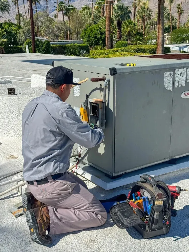 Technician inspecting electrical connections in an air conditioning unit